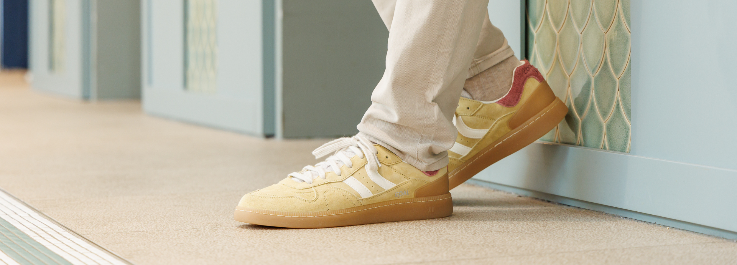 homme posé contre un mur avec des baskets coolway jaune 