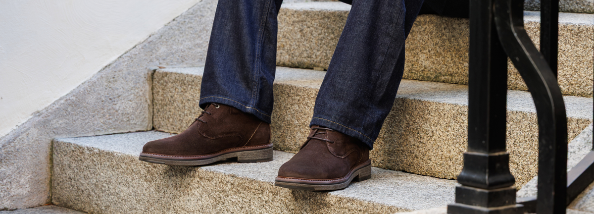 Homme assis dans les escaliers, portant une paire de bottines fluchos marron
