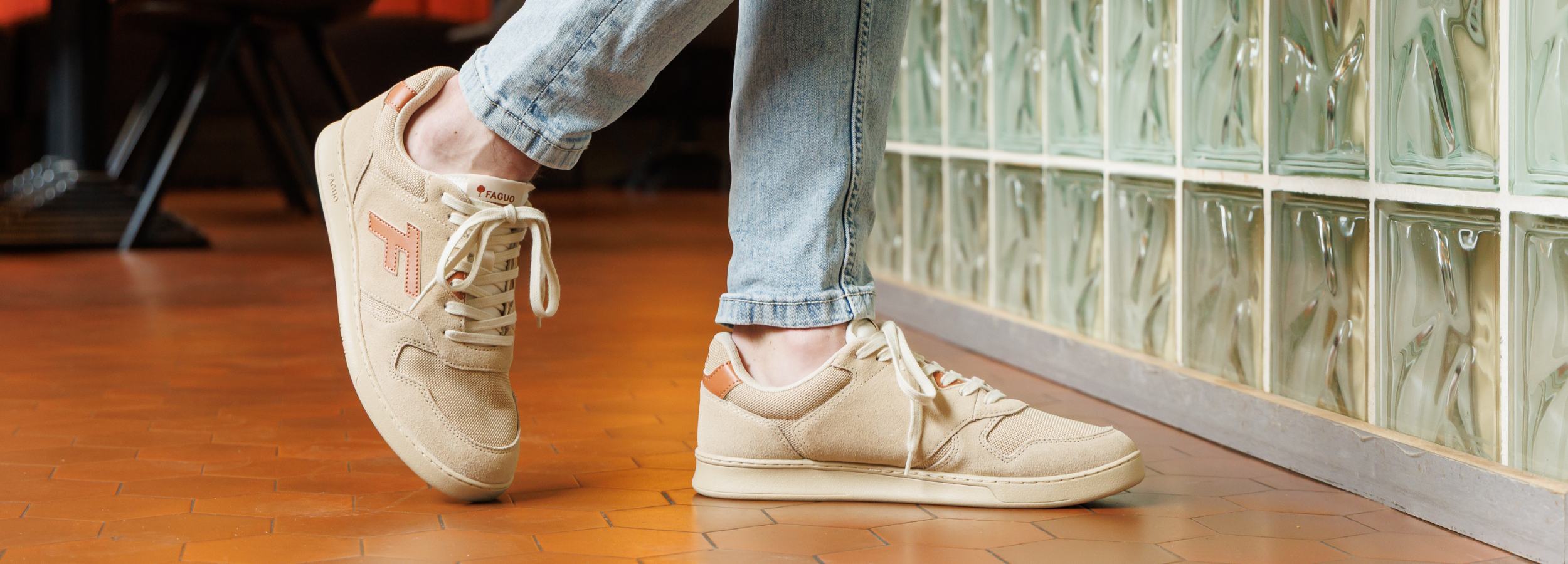 Photo d'un homme portant une paire de baskets faguo couleur beige, il porte un jeans