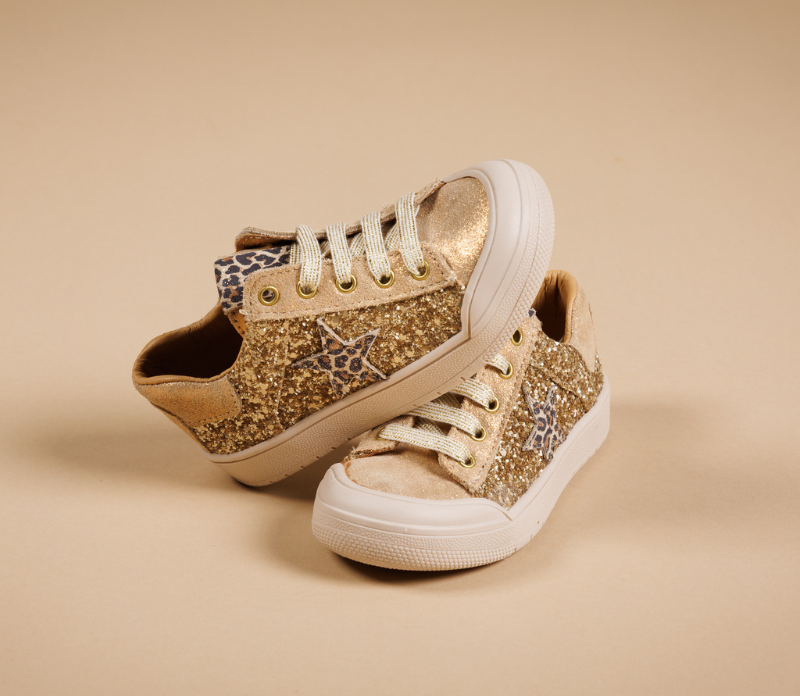 Baskets enfant de la marque bopy posées sur du fond beige