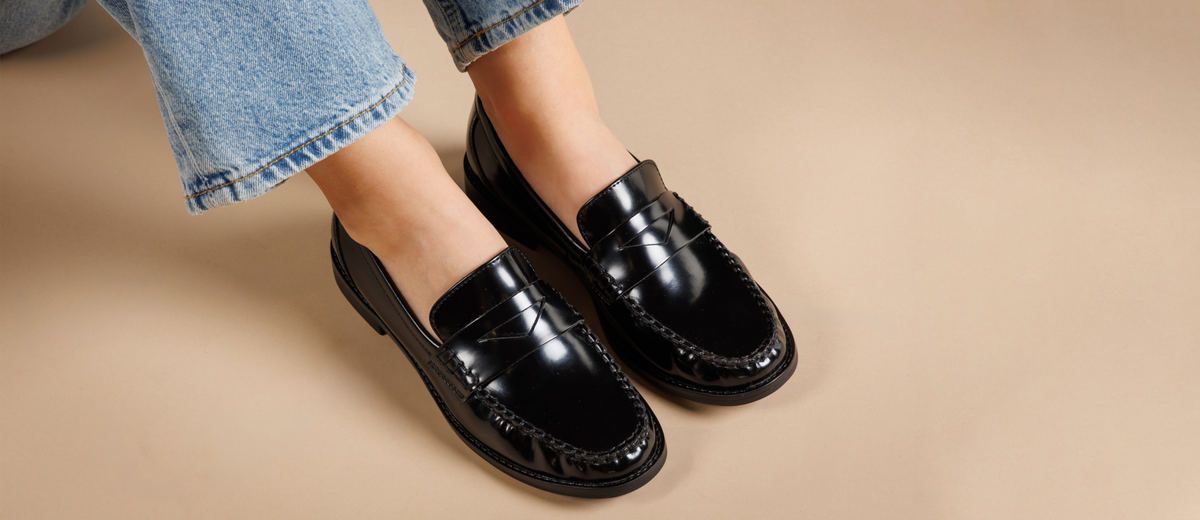 Femme portant des mocassins Marco tozzi, coloris noir, avec un fond beige