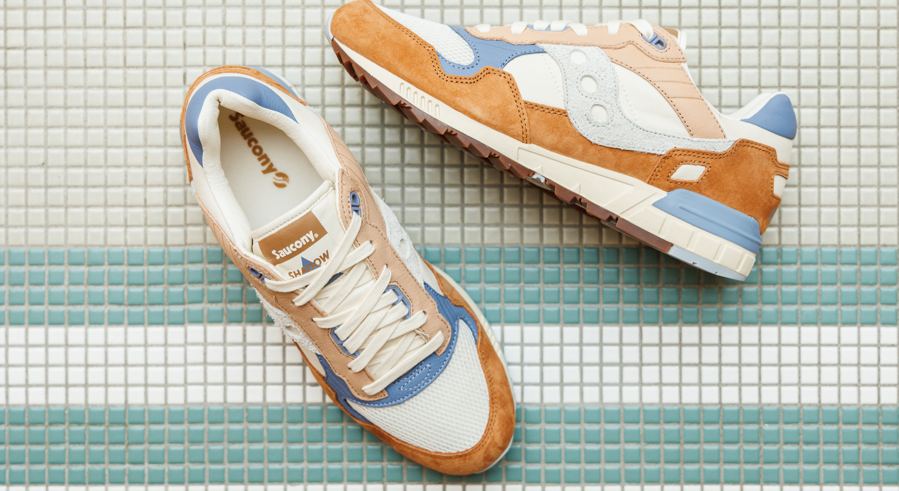 Sneakers homme de la marque saucony posées sur du carrelage