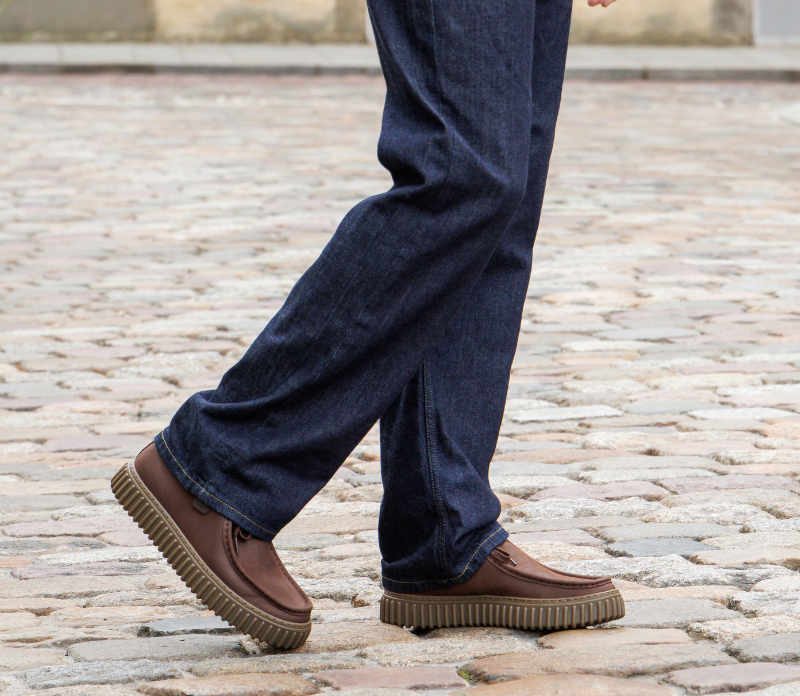 Homme portant une paire de derbies de la marque clarks, coloris marron